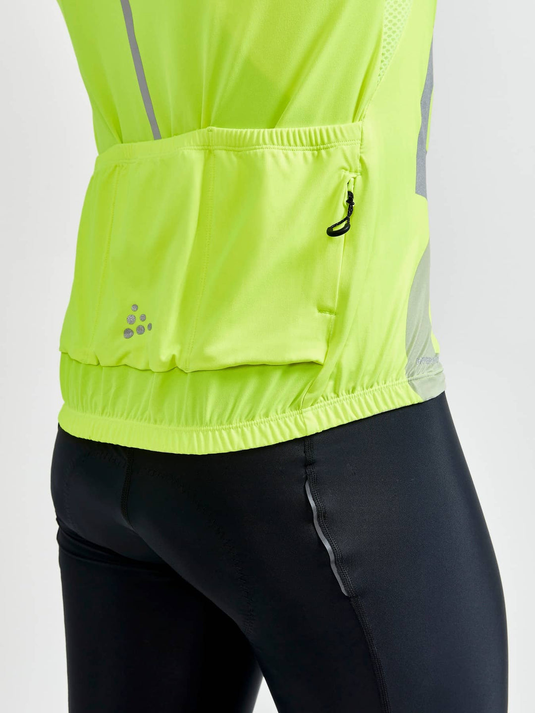 Person wearing a bright yellow reflective safety vest on a white background