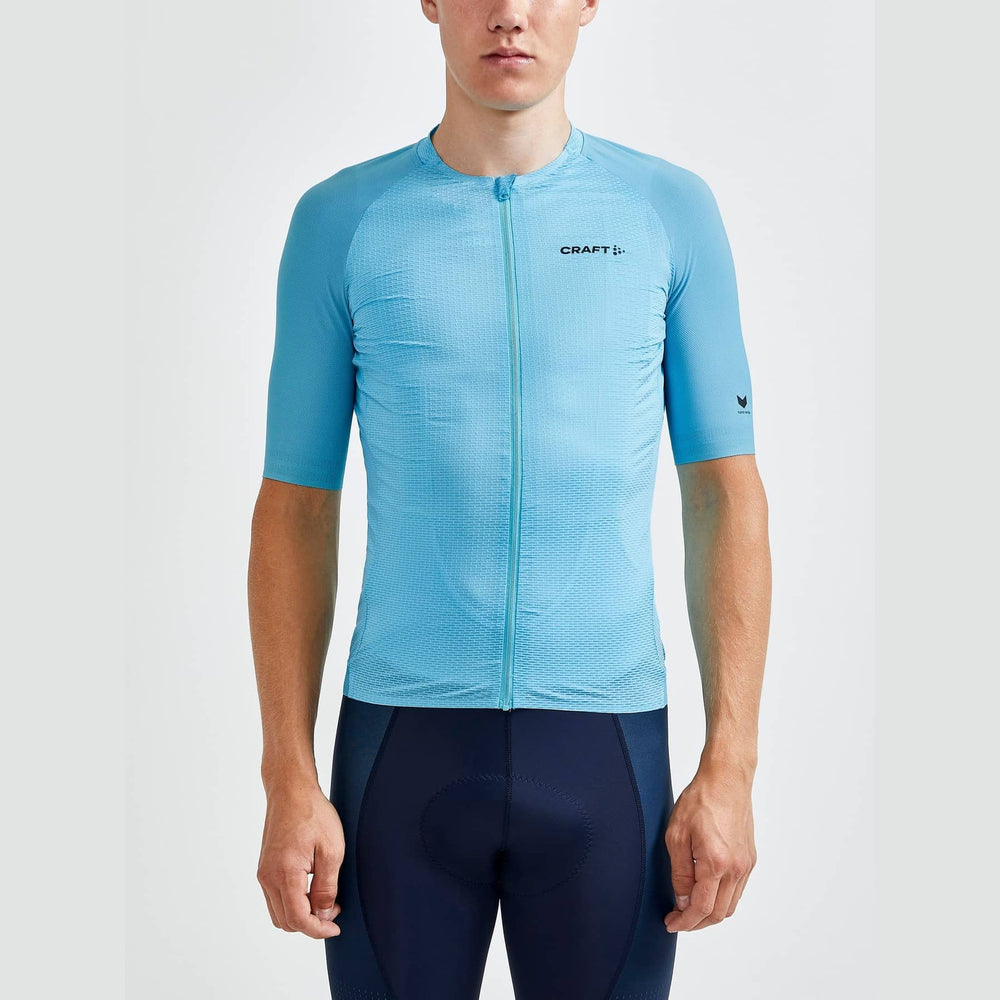 Person wearing a blue cycling jersey with 'Craft' branding on a white background
