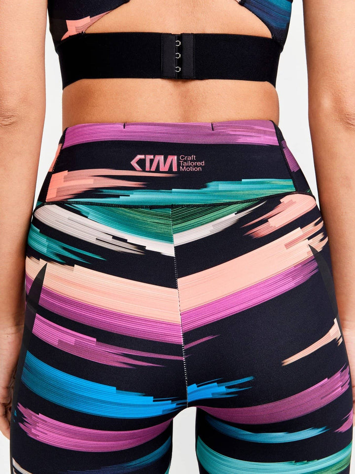 Colorful athletic shorts with abstract pattern and brand logo on a neutral background