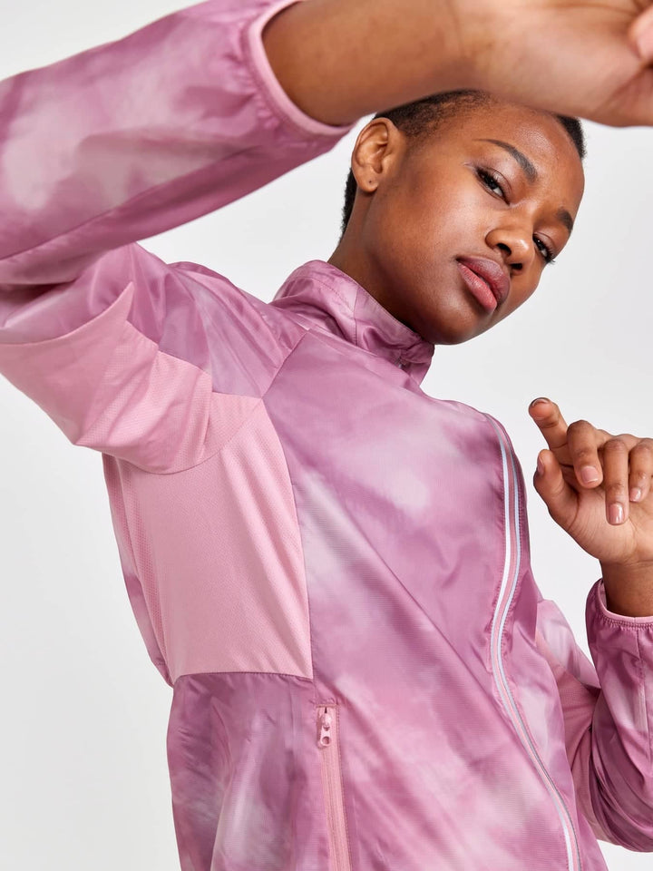 Person wearing a pink tie-dye jacket on a light gray background