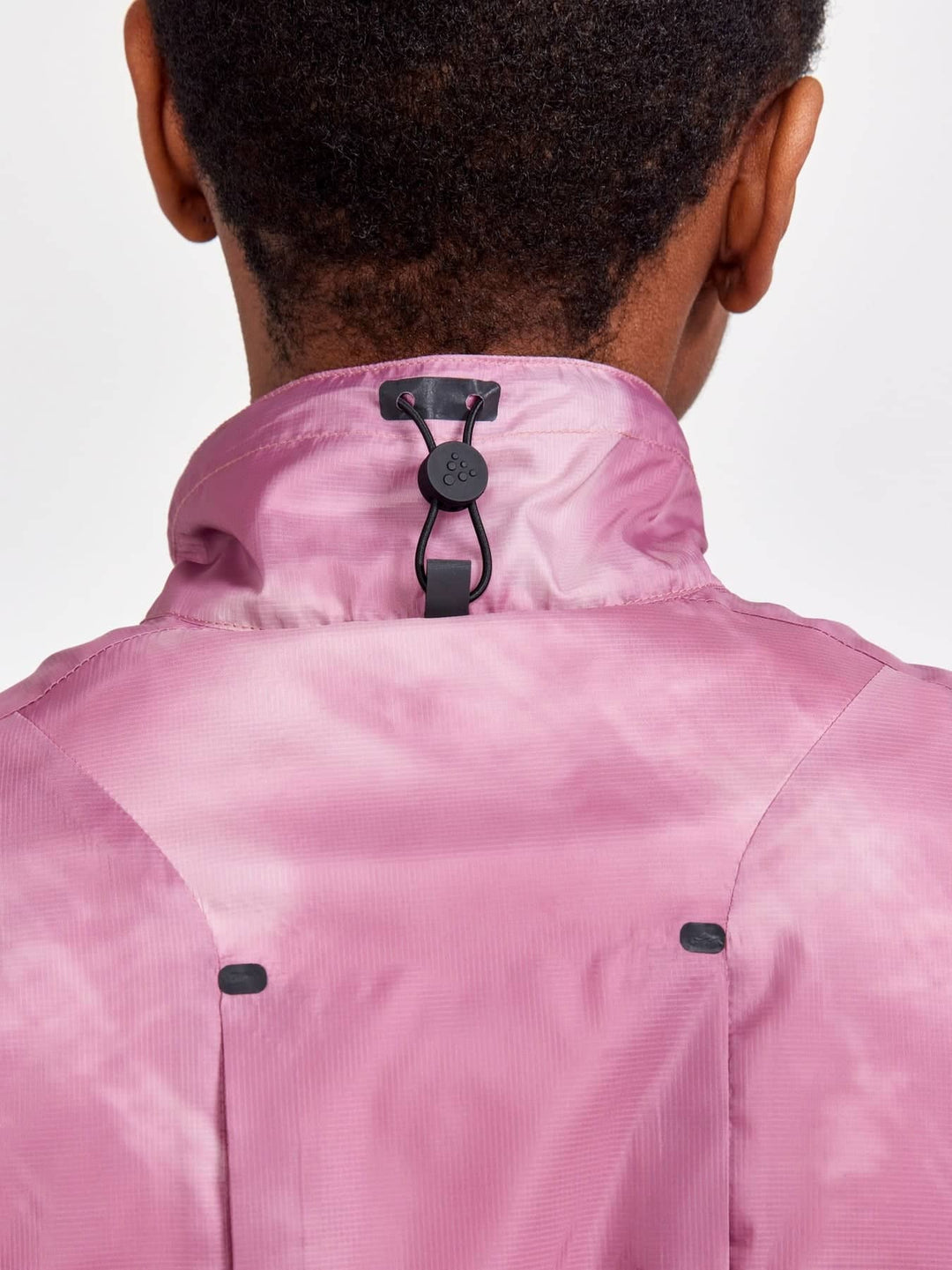 Pink jacket with black buttons on a plain background