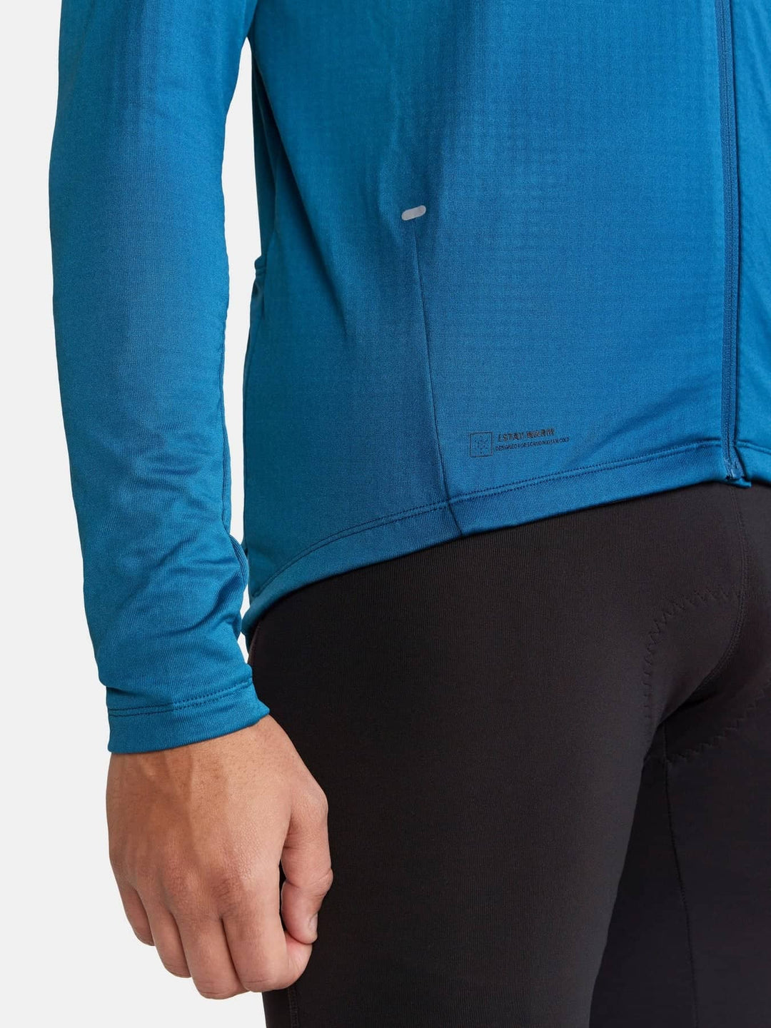 Blue long-sleeve athletic jacket worn by a person on a white background