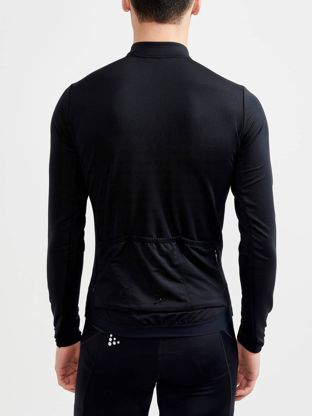 Person wearing a black long-sleeve athletic jacket on a white background