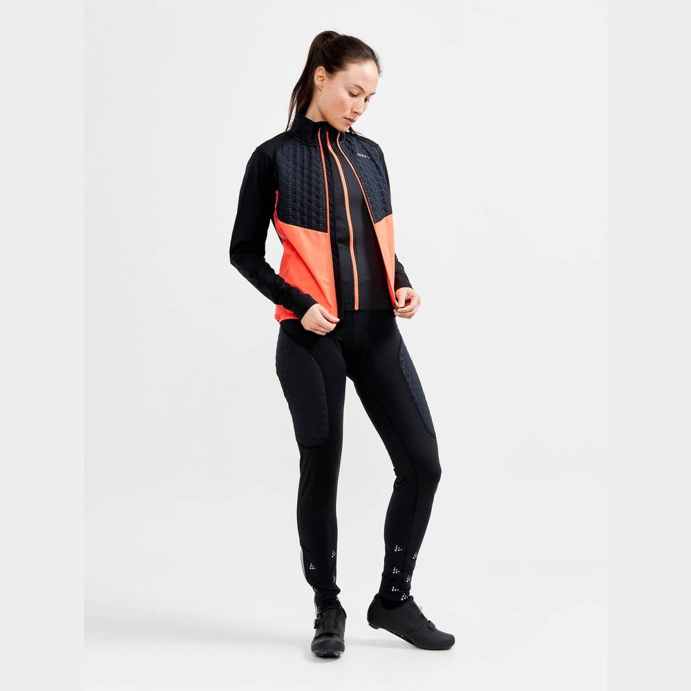 Woman wearing a black and orange jacket with black pants on a white background