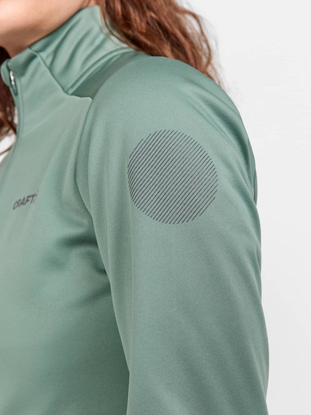 Green athletic jacket with elbow patch on a white background