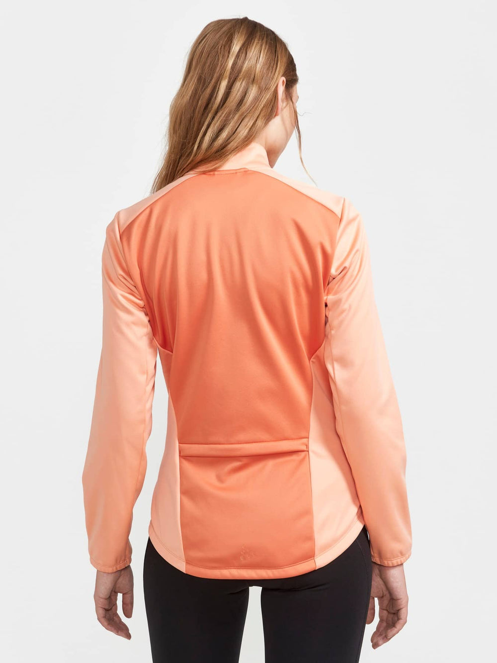 Person wearing a peach-colored long-sleeve athletic top on a white background