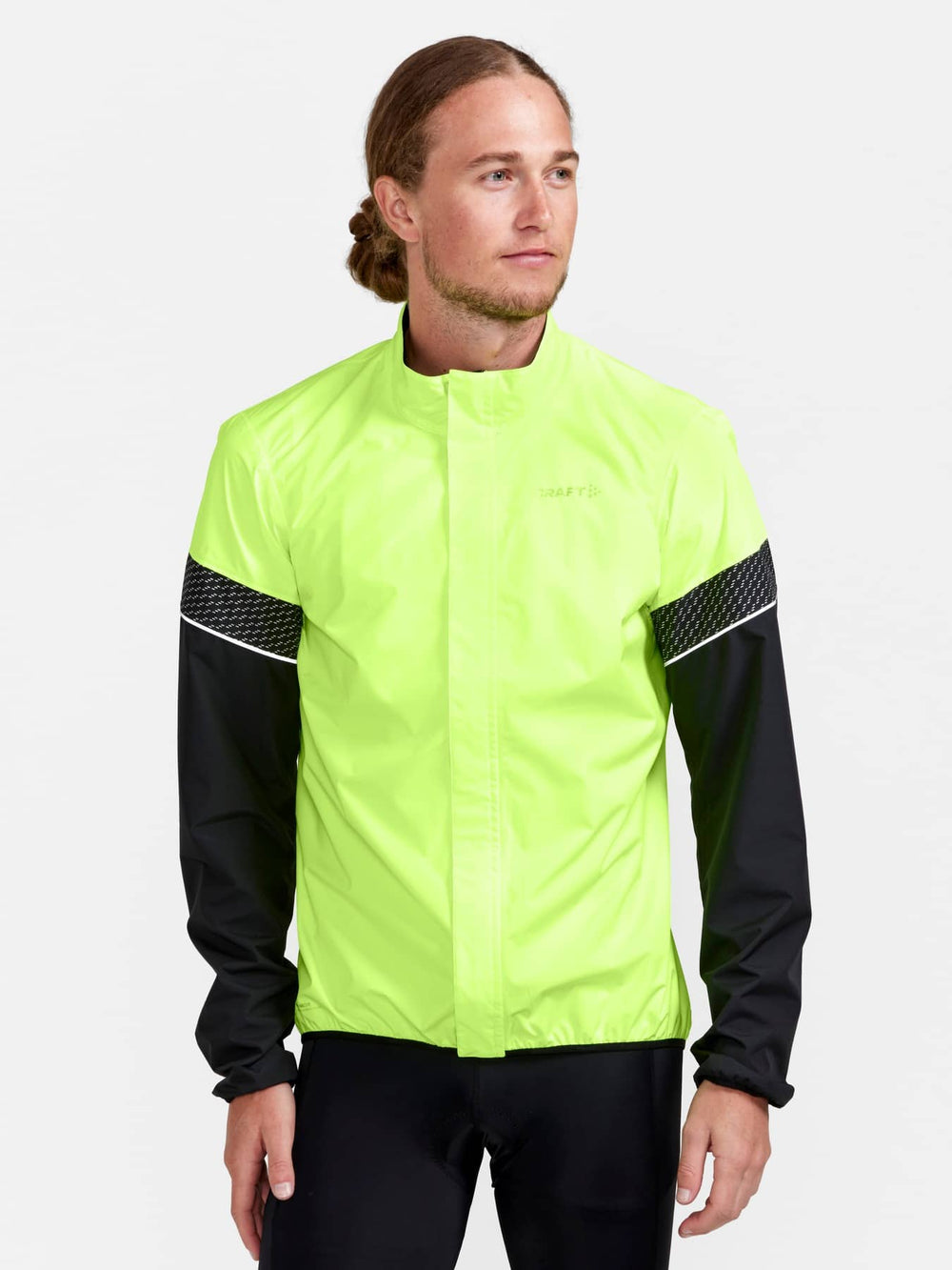 Person wearing a bright yellow-green jacket with black sleeves on a white background