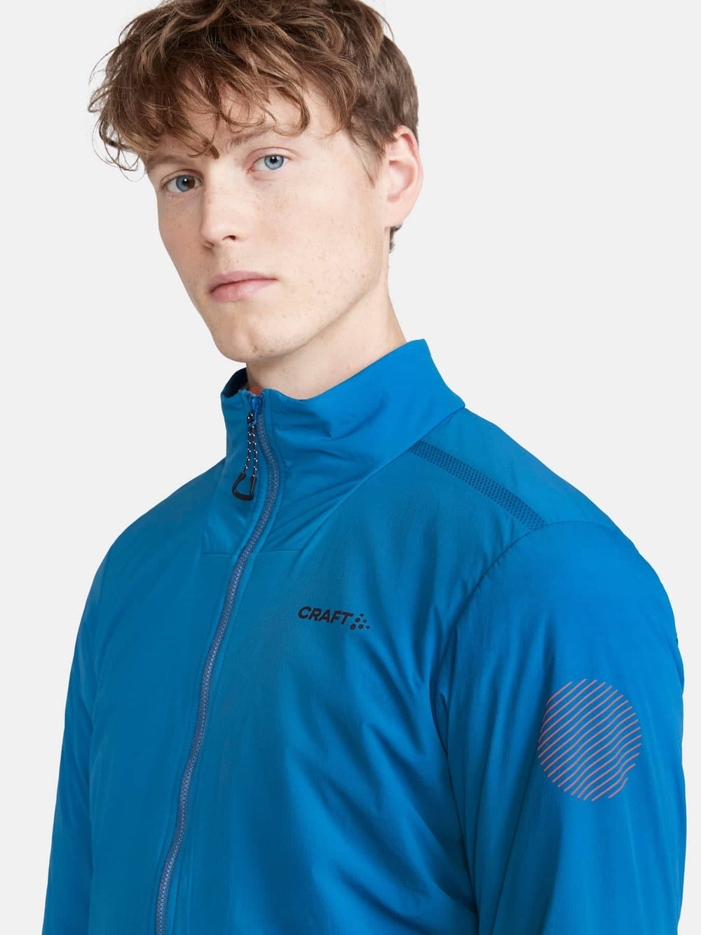 Person wearing a blue jacket with 'Craft' branding on a white background