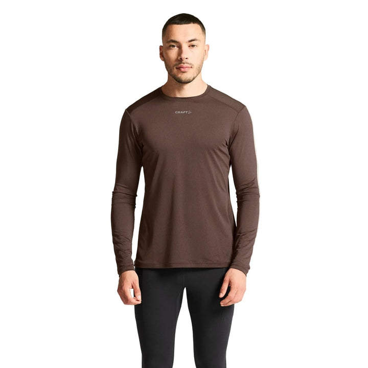 Male athlete wearing Craft ADV Essence LS Tee 2 in Prune, lightweight performance shirt designed for running and fitness training.