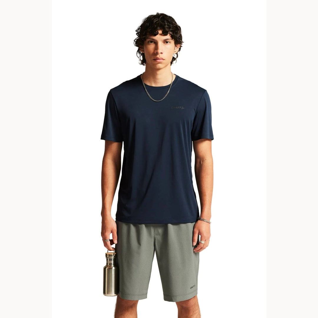 Male model wearing Craft Core Essence SS Tee 2 in Blaze, lightweight training shirt designed for running, gym workouts, and fitness activities.