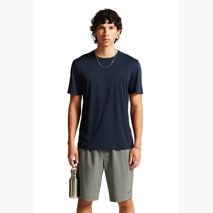 Male model wearing Craft Core Essence SS Tee 2 in Blaze, lightweight training shirt designed for running, gym workouts, and fitness activities.