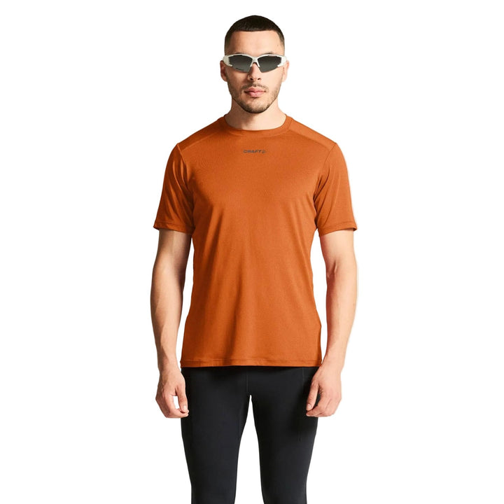 Male athlete wearing Craft ADV Essence SS Tee 2 in Buff, lightweight performance shirt designed for running and fitness training.