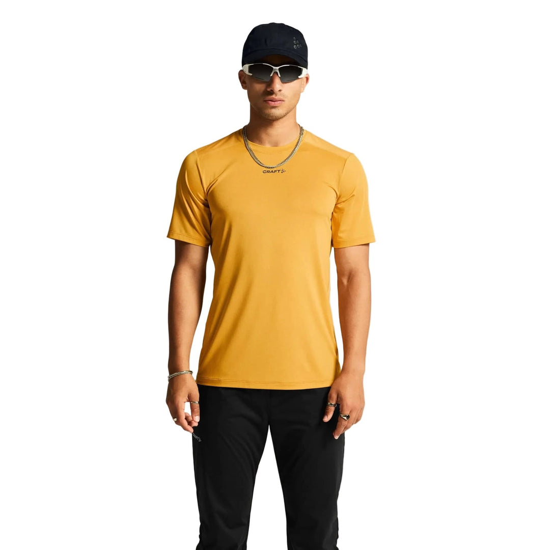 Male athlete wearing Craft ADV Essence SS Tee 2 in Turmeric, lightweight performance shirt designed for running and fitness training.