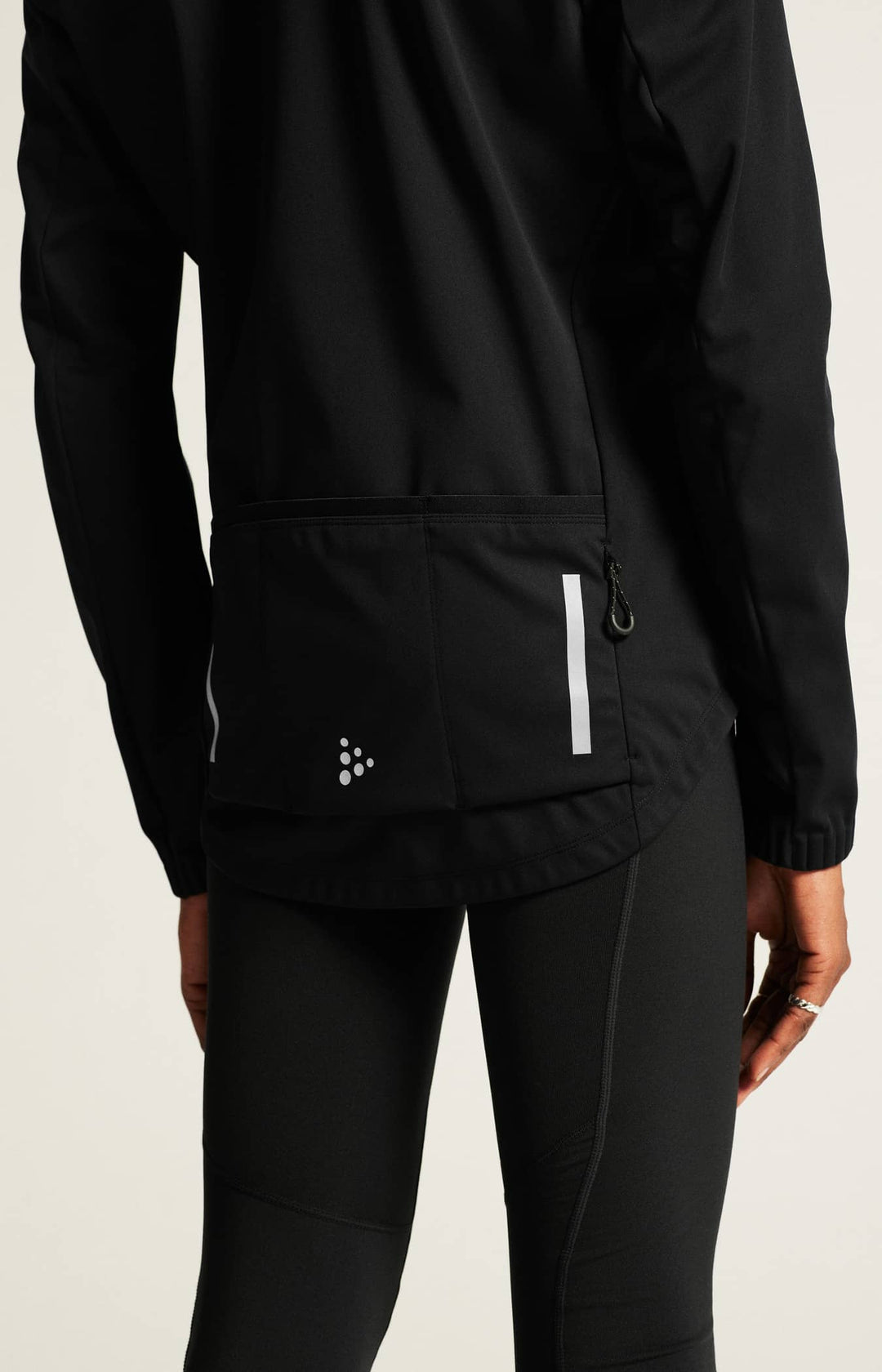 Black athletic jacket and pants on a neutral background