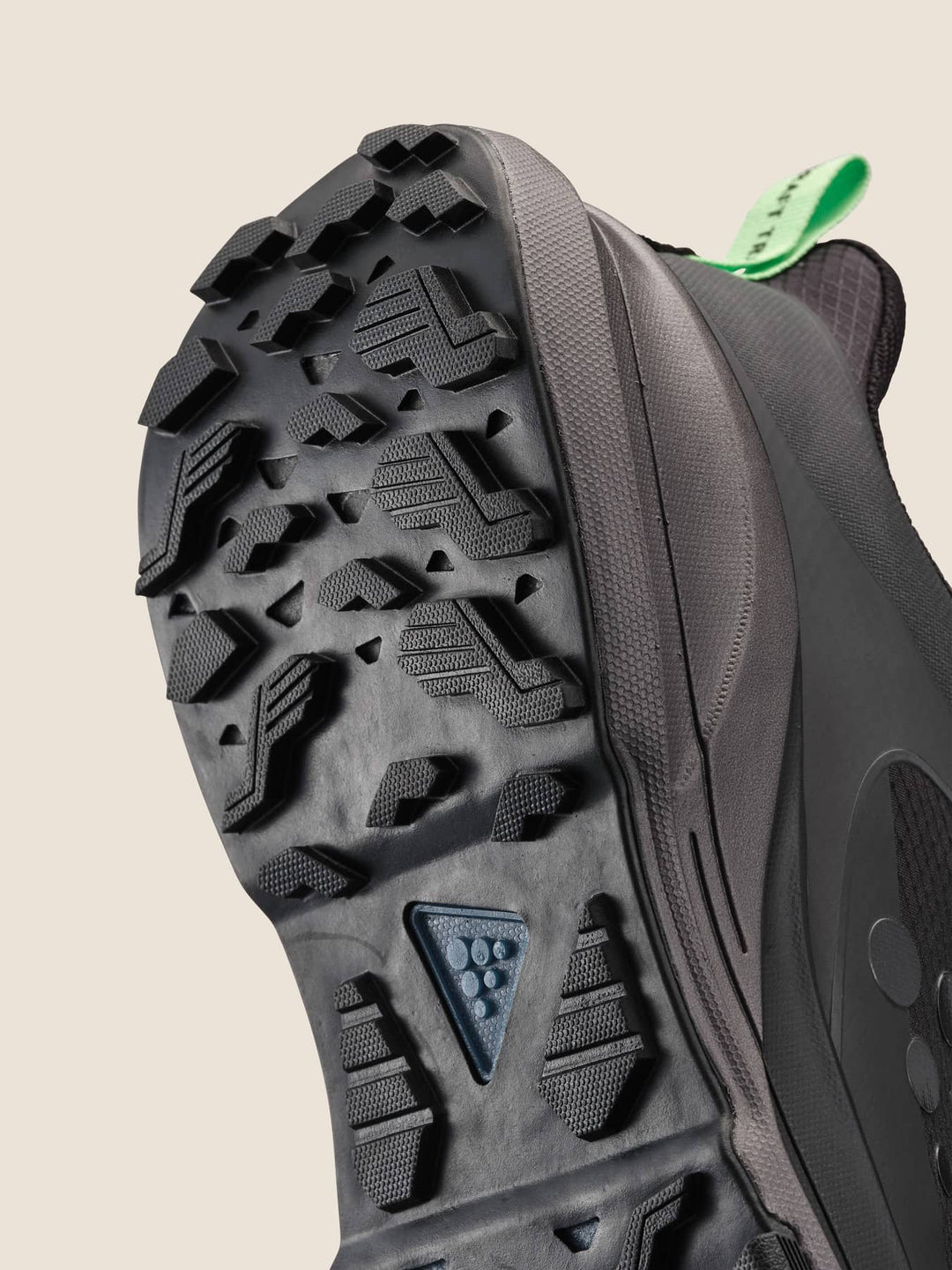 Close-up of a hiking shoe sole with tread pattern on a beige background