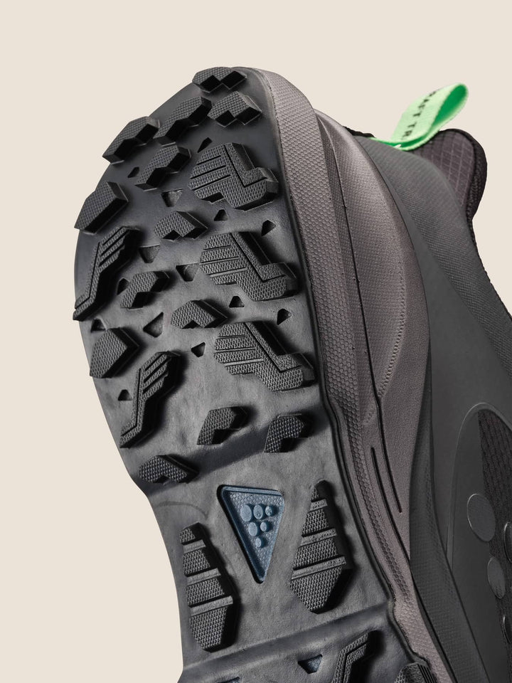 Close-up of a hiking shoe sole with tread pattern on a beige background
