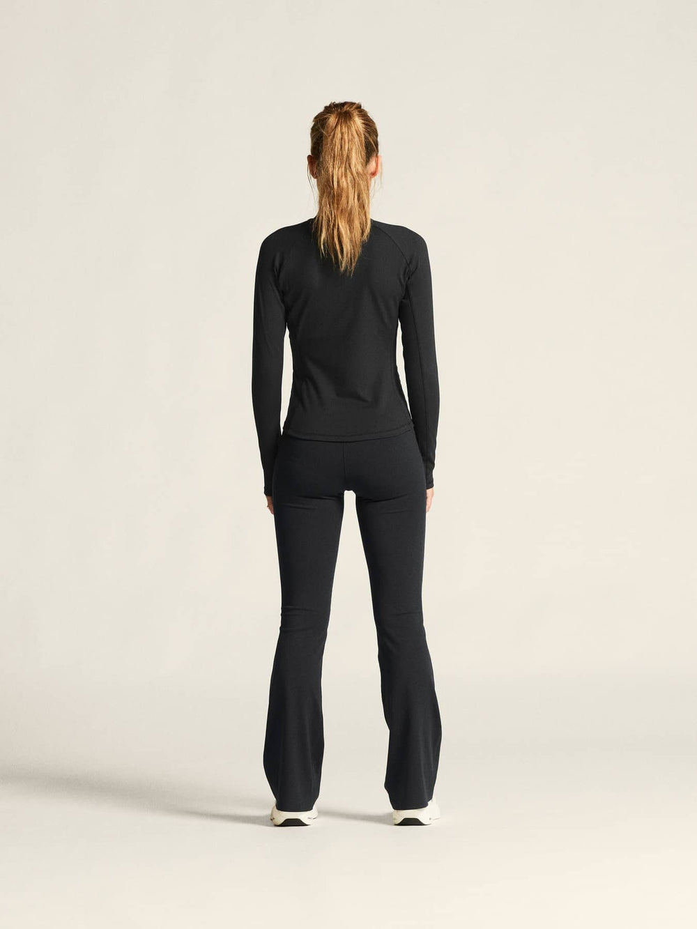 Person wearing a black outfit on a plain background