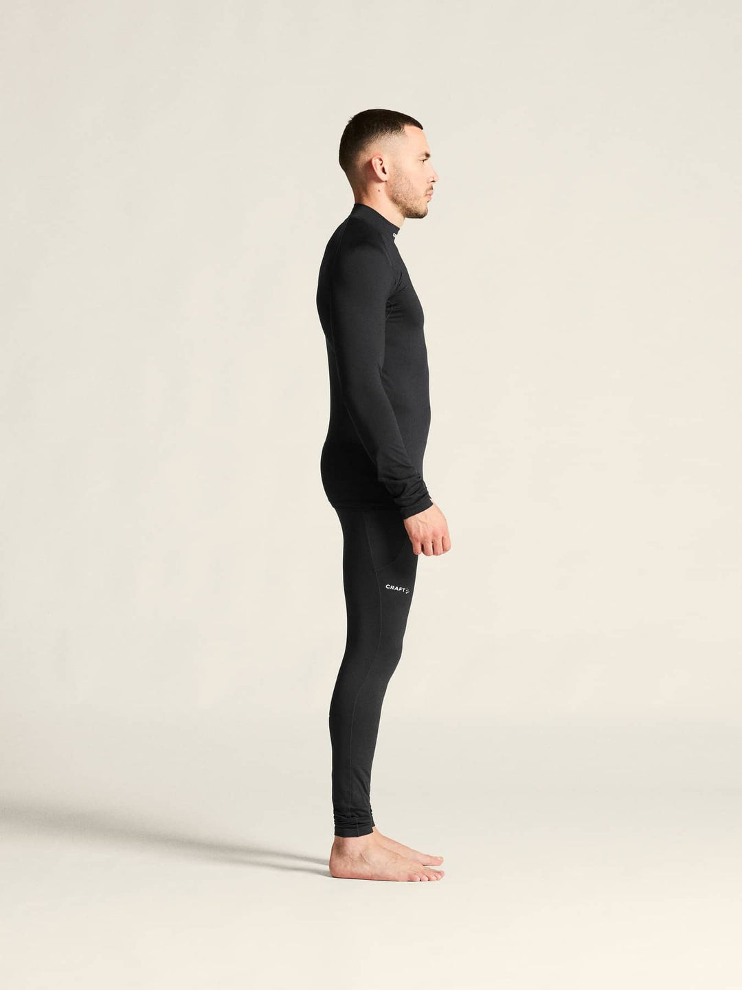 Person wearing a black full-body suit on a plain background