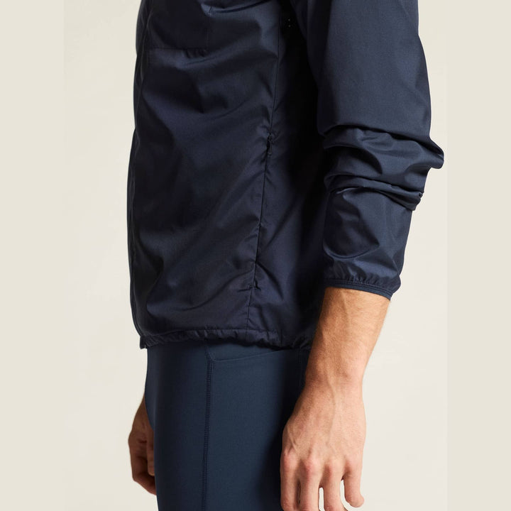 Navy blue jacket worn by a person on a beige background