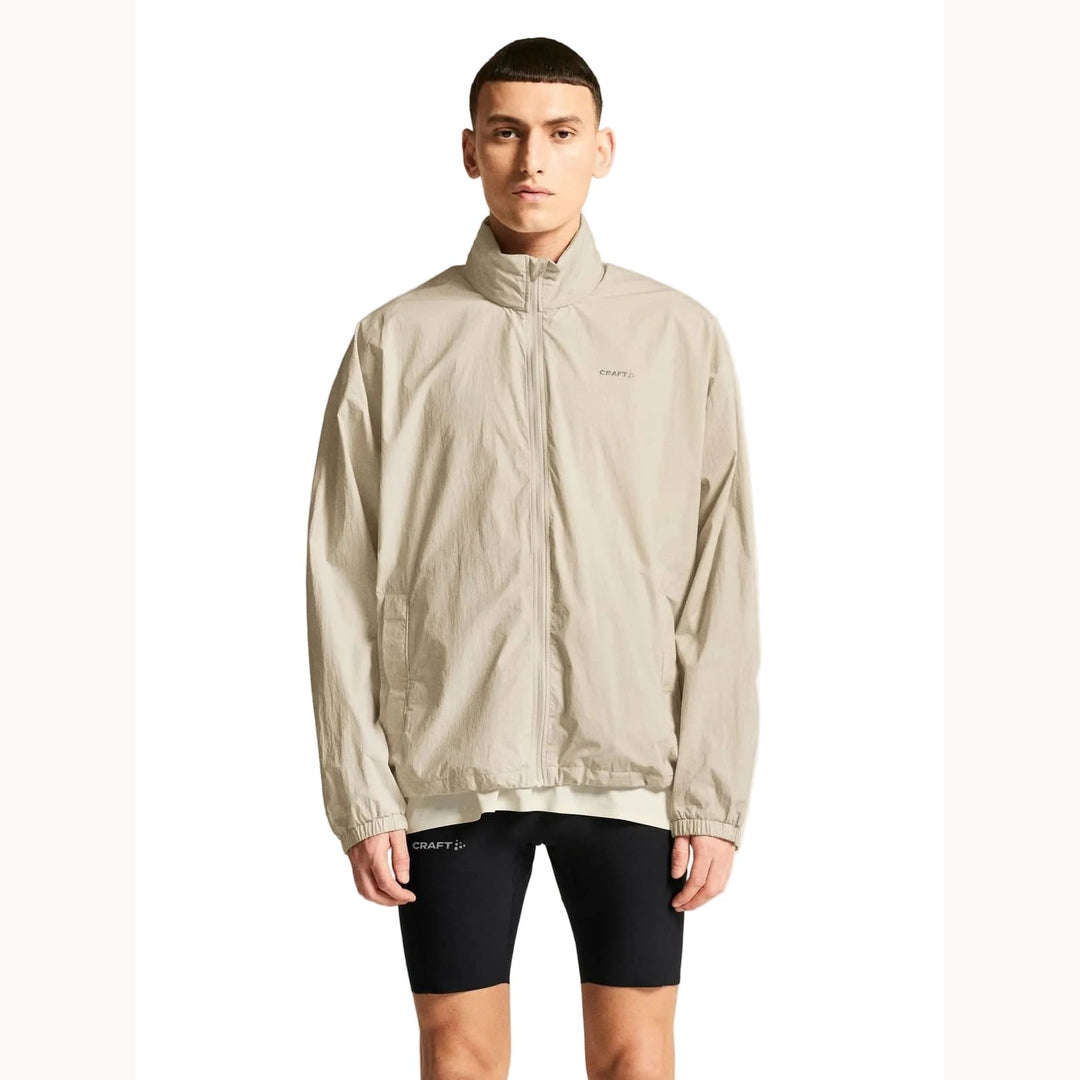 Male athlete wearing Craft Hypervent Oversized Wind Jacket in Plaster, lightweight running jacket designed for wind protection and training comfort.