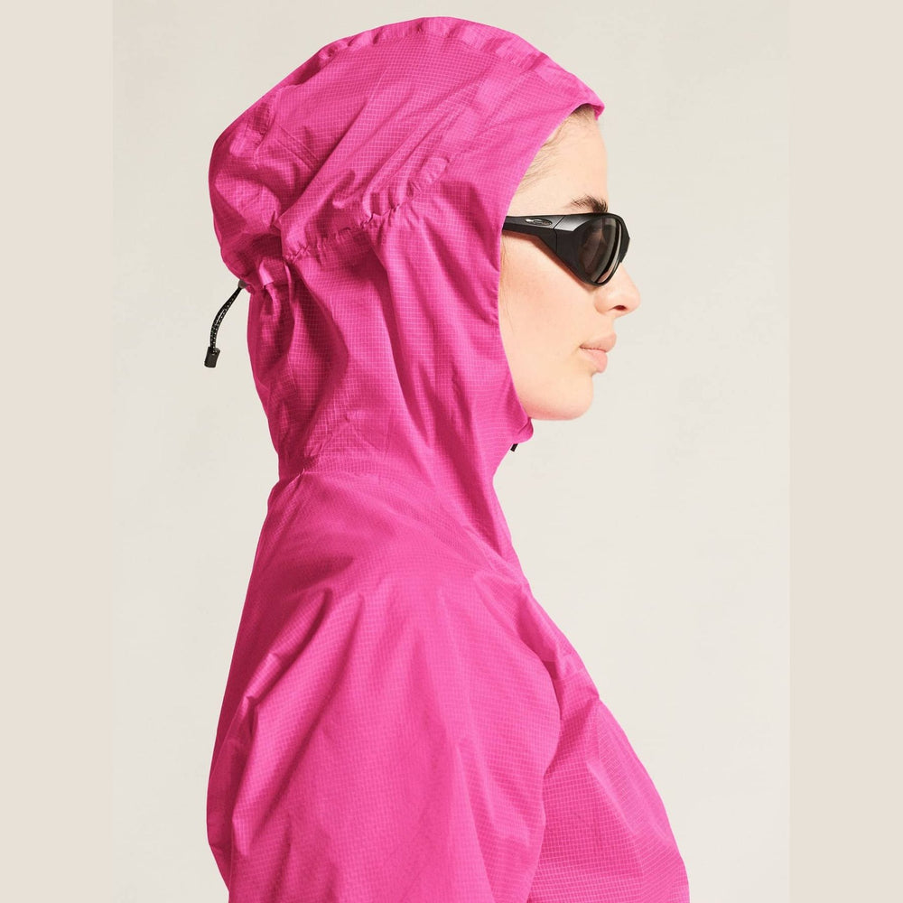 Person wearing a bright pink hooded jacket on a plain background