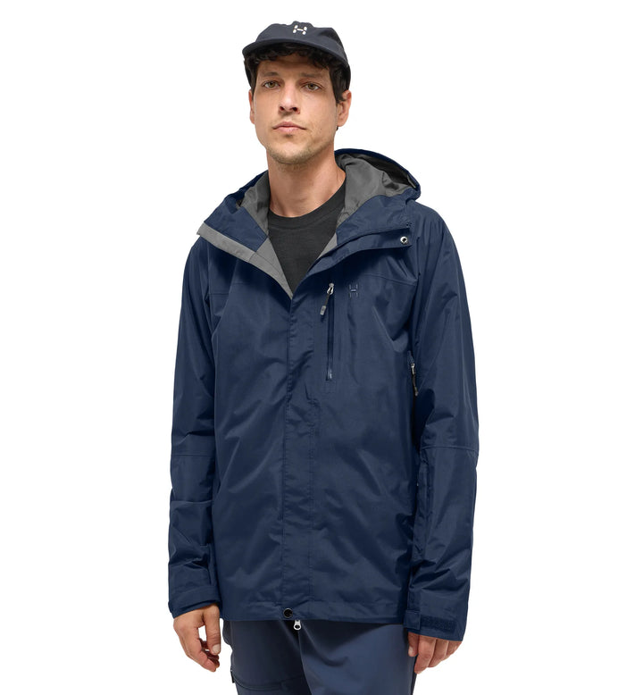 Man wearing a navy blue raincoat with gray hood on a white background
