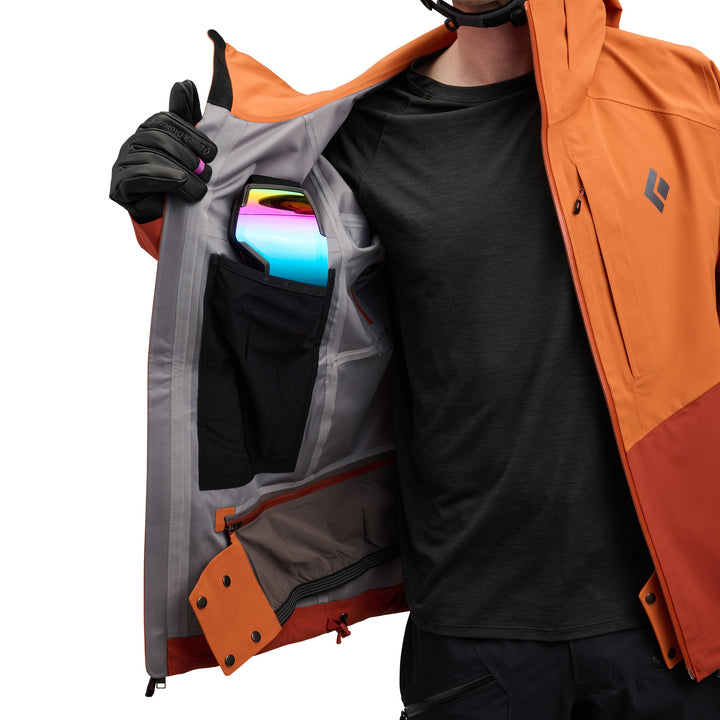 Person wearing an orange and gray jacket with a colorful object in the pocket on a white background