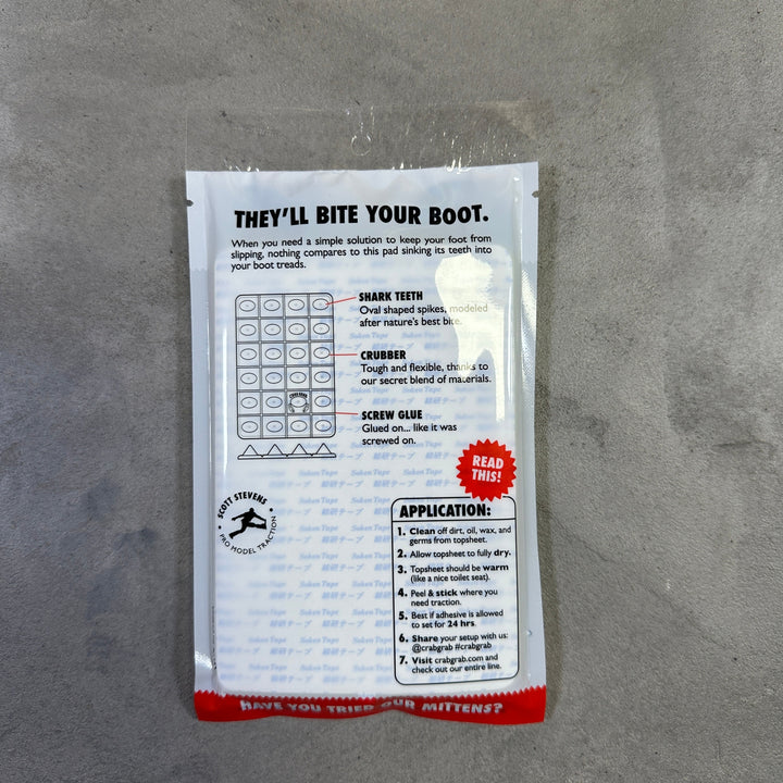 Small rectangular package with text and a logo on a gray surface