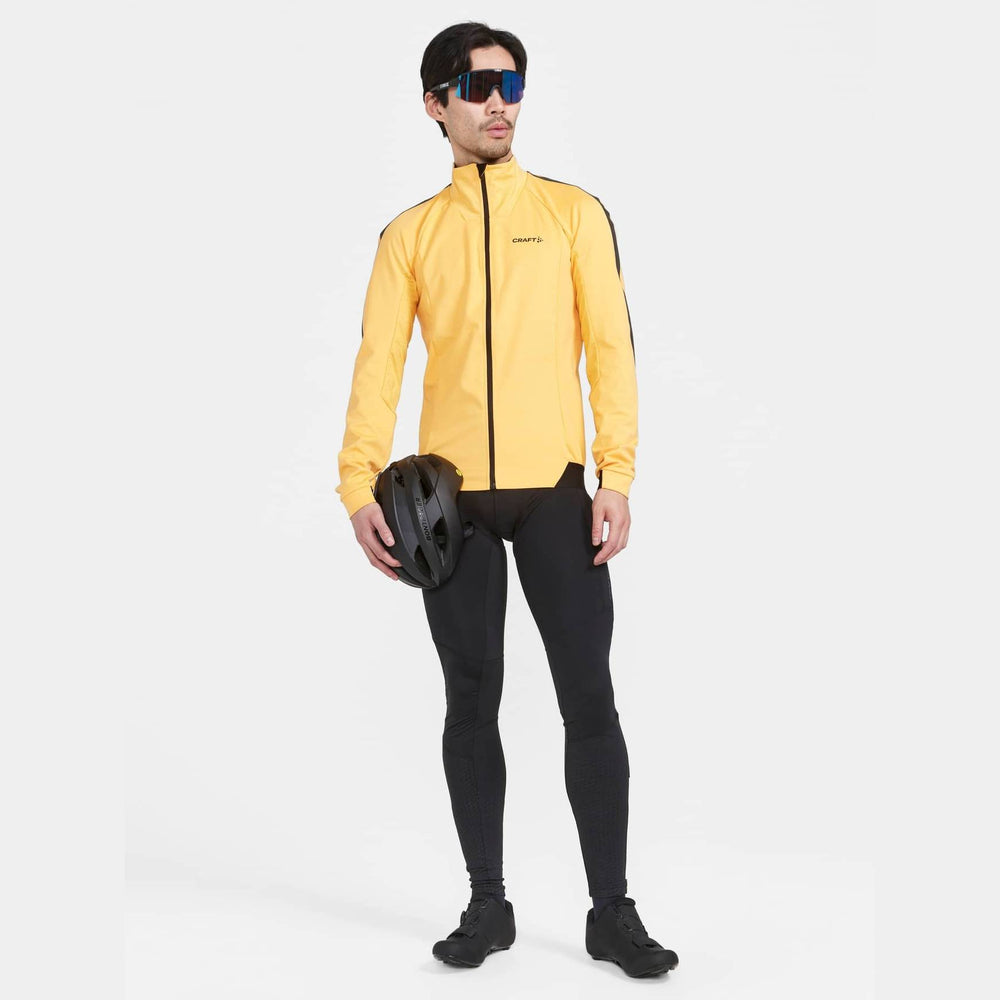 Person wearing a yellow cycling jacket and black leggings with a helmet on a white background
