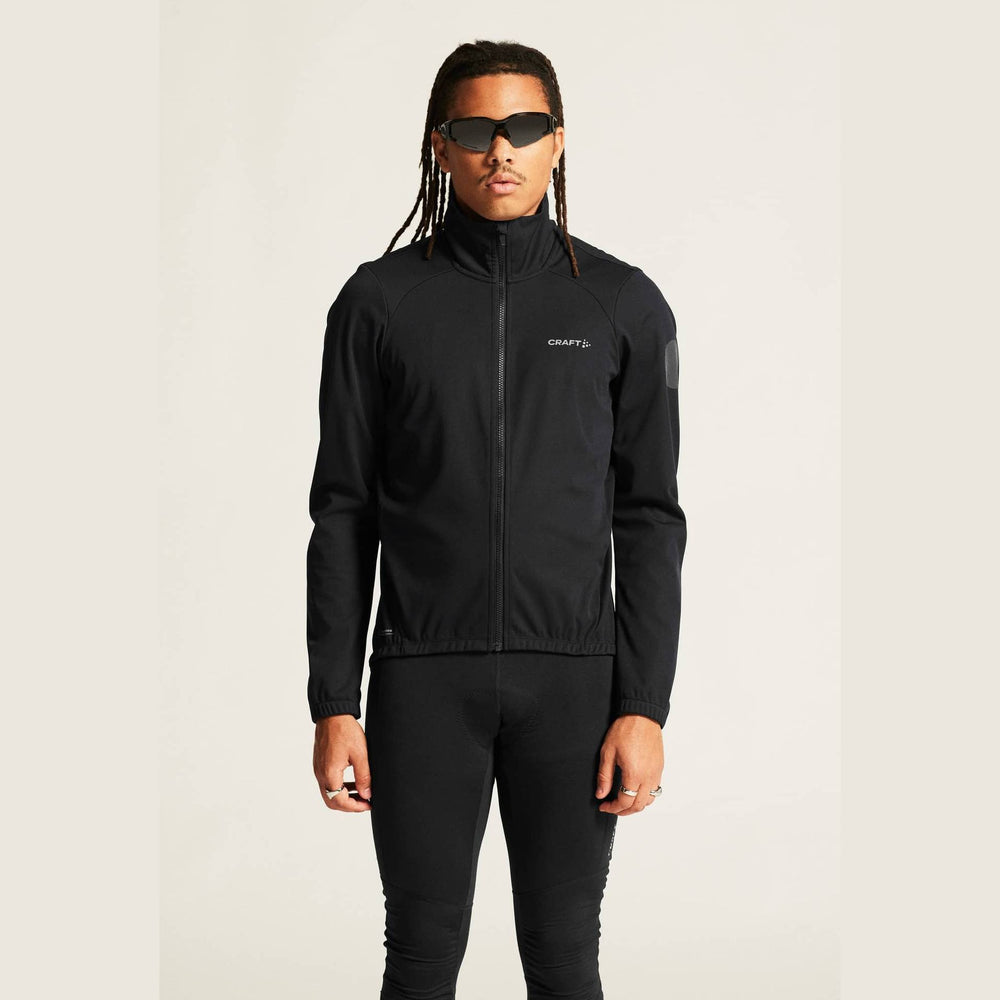 Person wearing a black jacket with a brand logo on a plain background