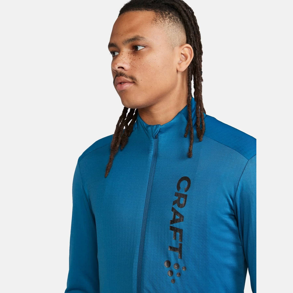 Person wearing a blue athletic jacket with 'Craft' branding on a white background