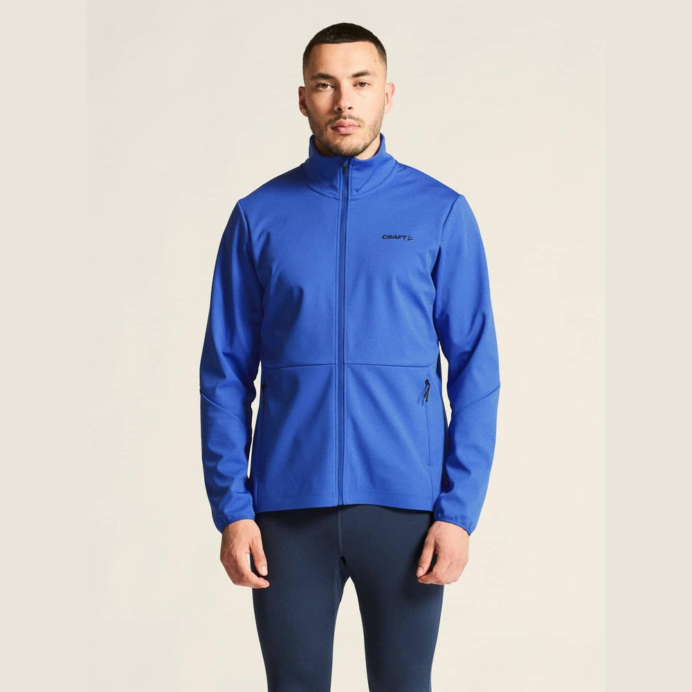 Man wearing a blue jacket with a visible brand logo on a beige background