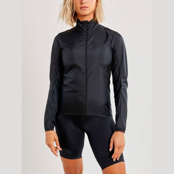 Person wearing a black running jacket and shorts on a light gray background