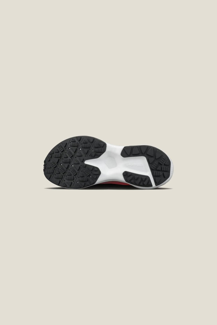 Black sandal with white floral embellishments on a white background