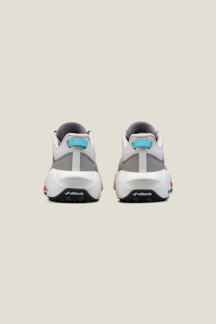 Pair of white and gray sneakers with blue accents on a beige background