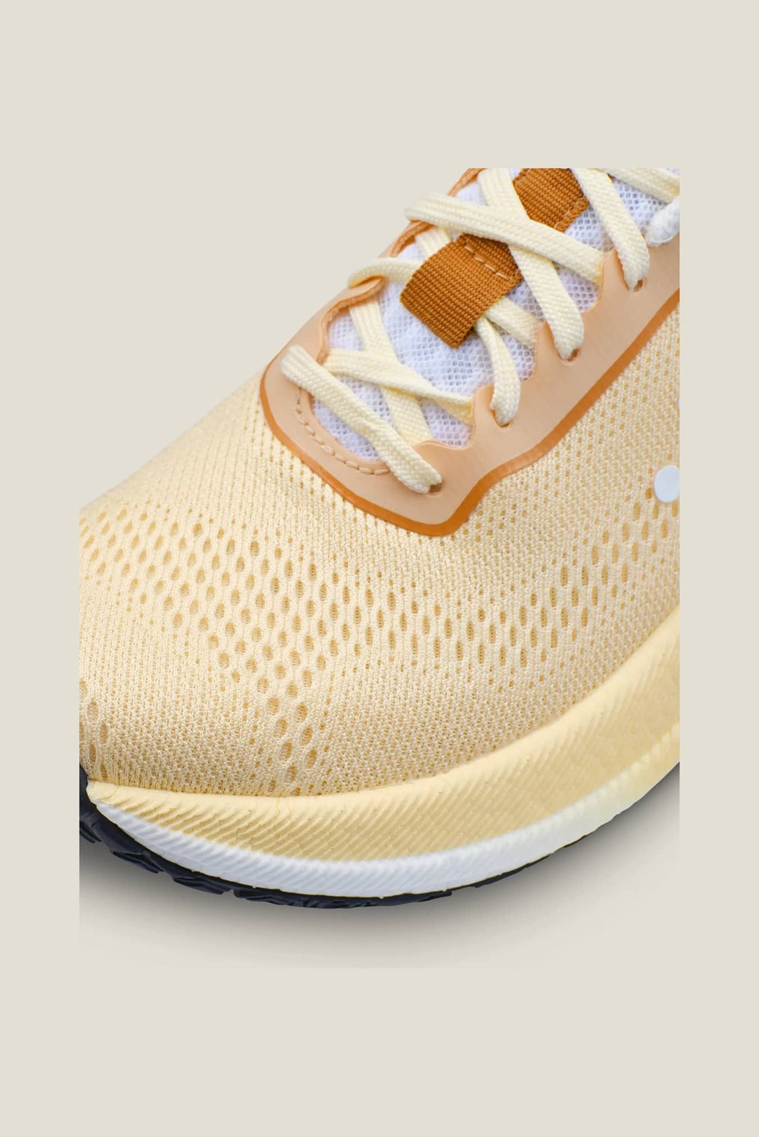Beige sneaker with white laces on a beige background