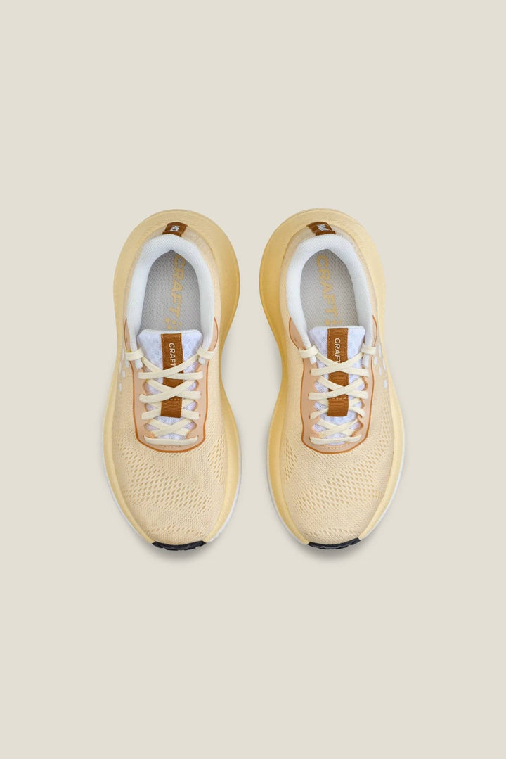 Pair of beige running shoes on a light beige background