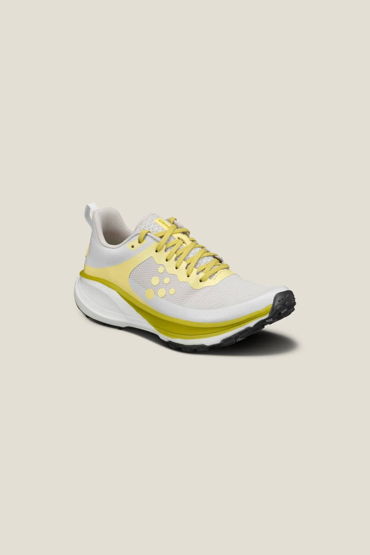 White and yellow running shoe on a beige background