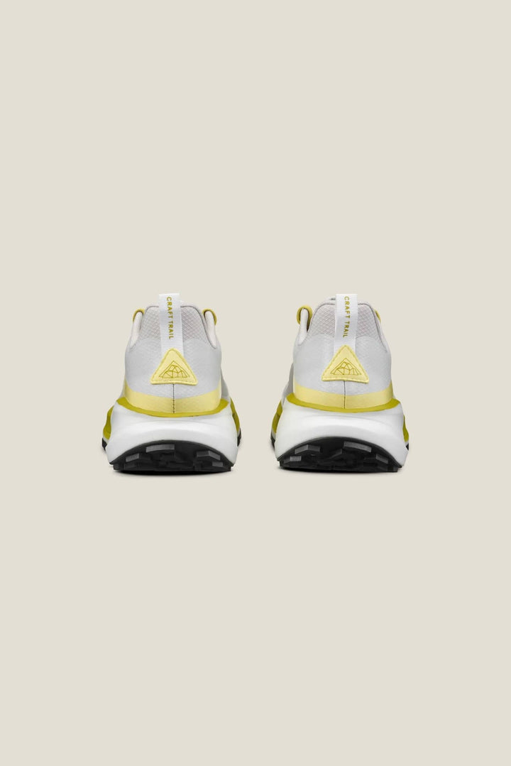 White sneakers with yellow accents on a beige background