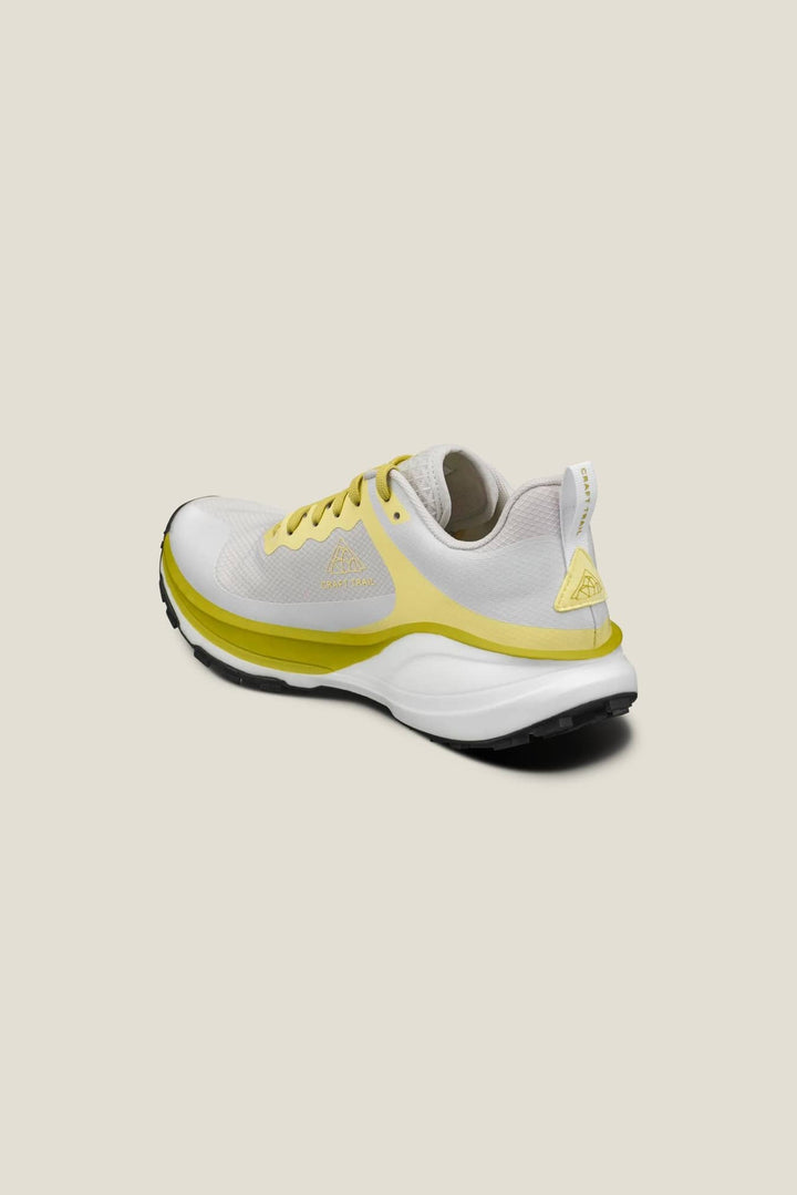 White and yellow running shoe on a beige background