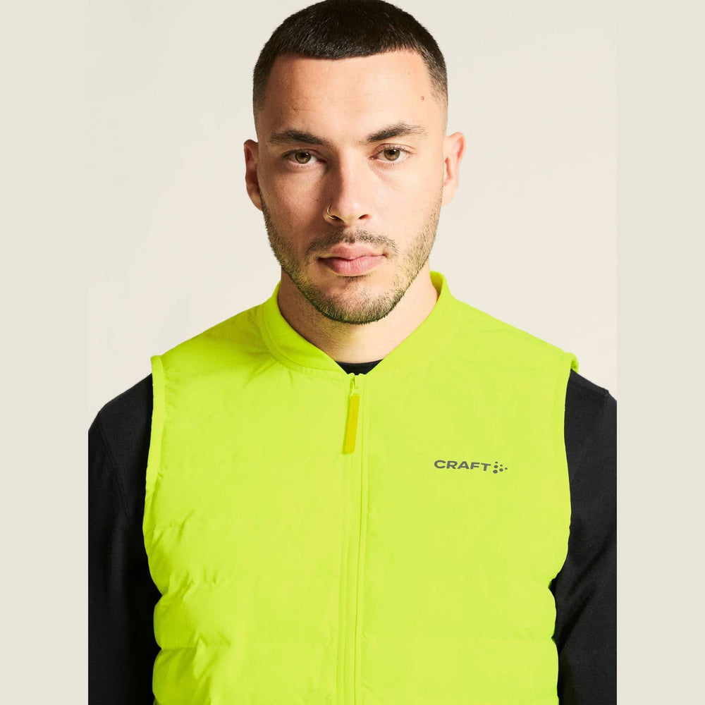 Man wearing a bright yellow vest with 'Craft' branding on a plain background
