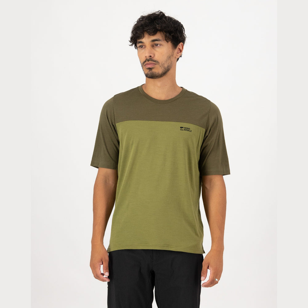 Man wearing a green t-shirt with a logo on a white background