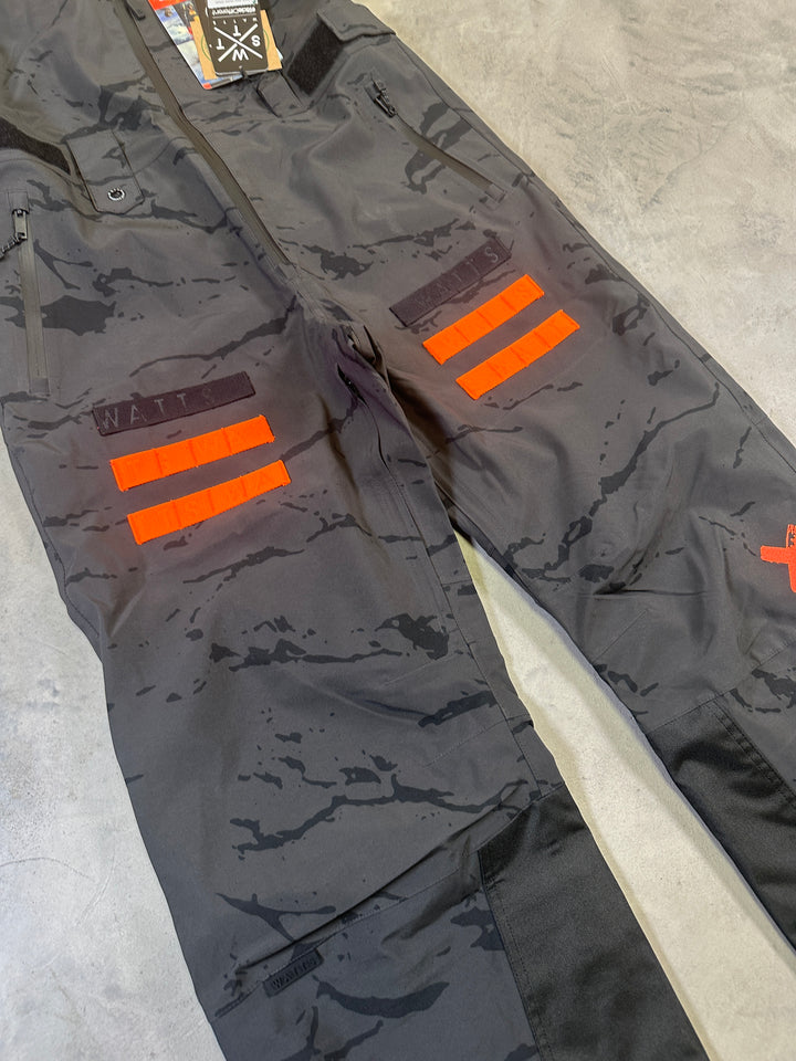 WATTS Cork Bib Pants with waterproof breathable fabric, adjustable bib straps, reinforced lower legs, and snow gaiters.