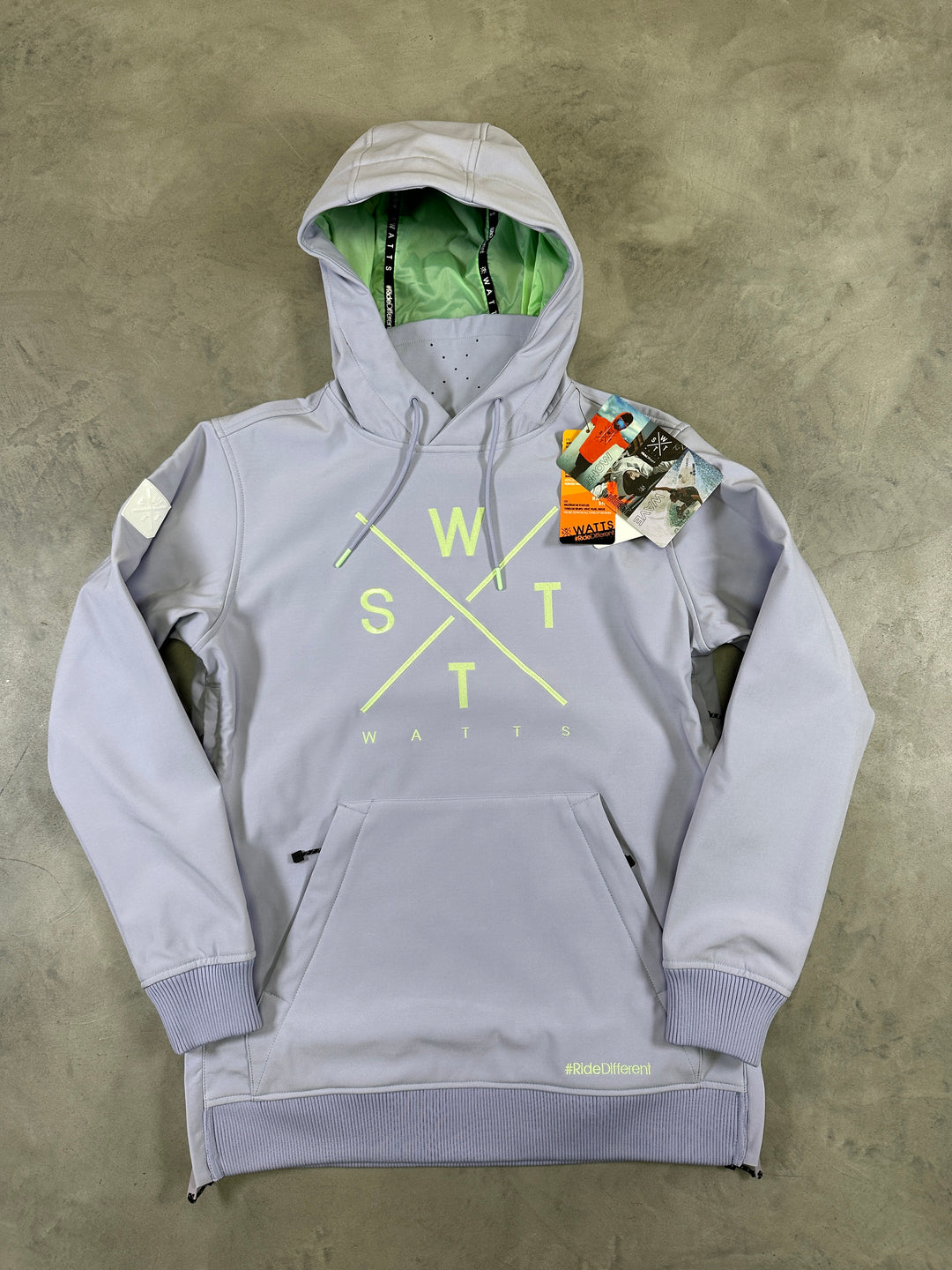 Gray hoodie with neon yellow text on a concrete floor