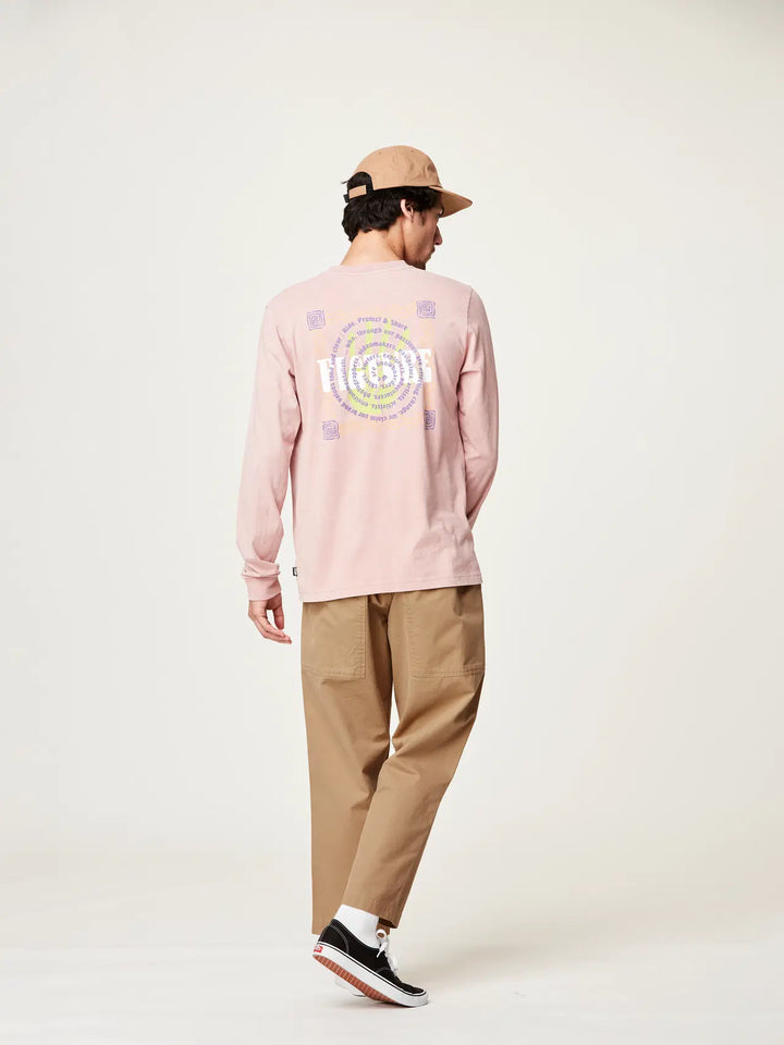 Person wearing a pink long-sleeve shirt with a logo, beige pants, and a cap on a white background