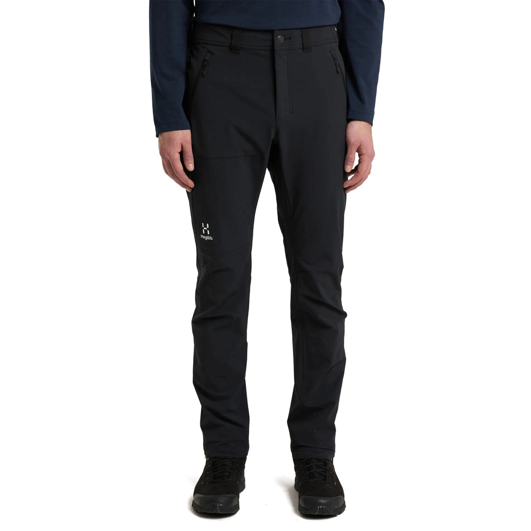 Black pants worn by a person on a white background