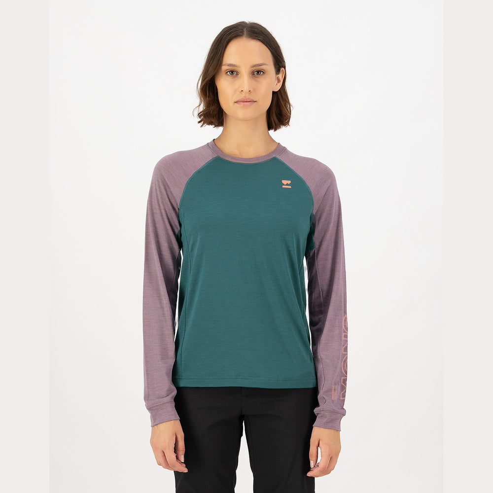 Person wearing a teal and purple long-sleeve shirt on a white background