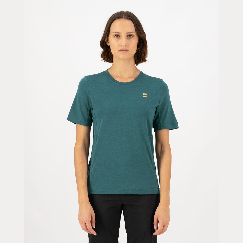 Person wearing a teal t-shirt with a small logo on a white background