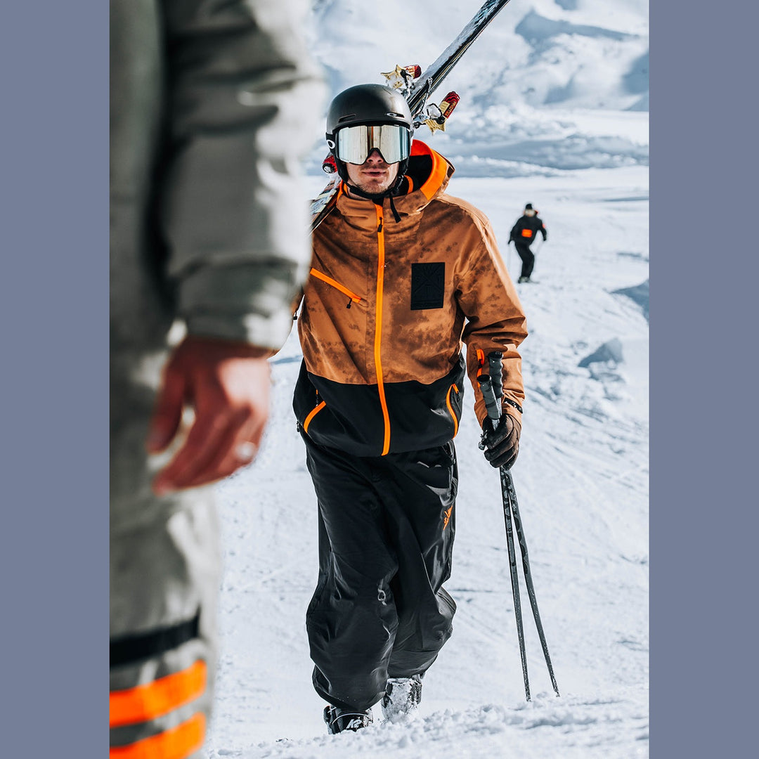 Person in winter gear with skis and poles on a snowy landscape