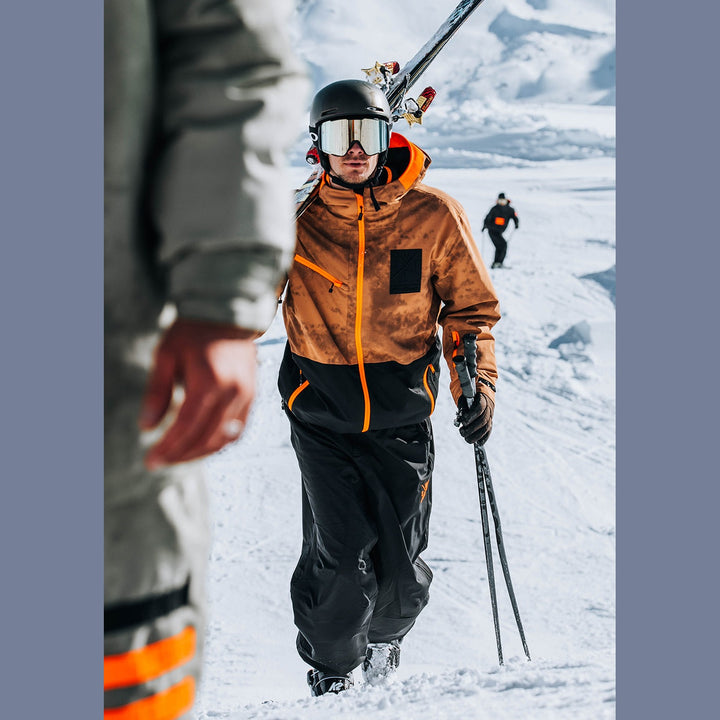 Person in winter gear with skis and poles on a snowy landscape